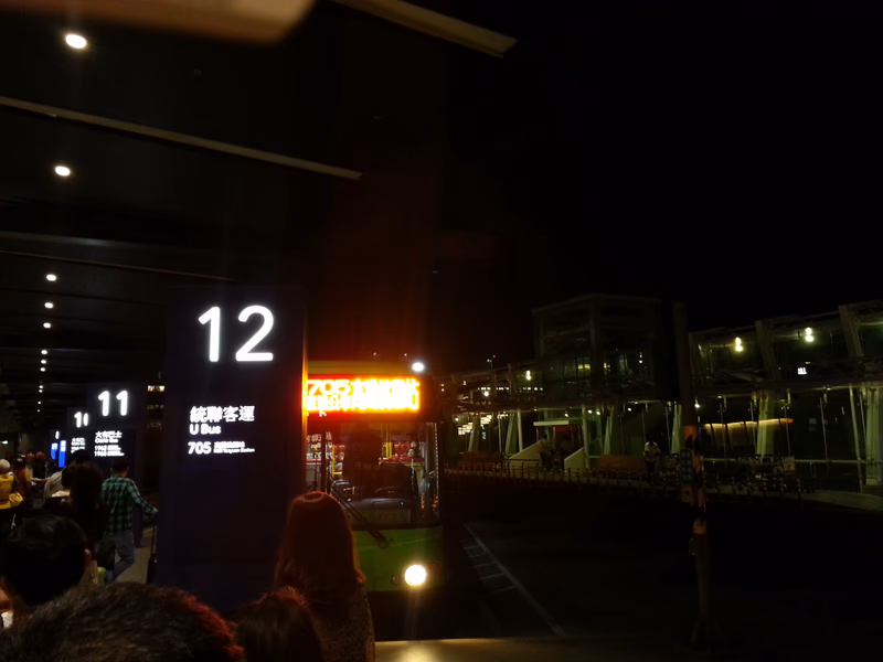 A night scene at Taoyuan City, Taiwan, featuring a sign with the number 12 and a bright sign in the background.